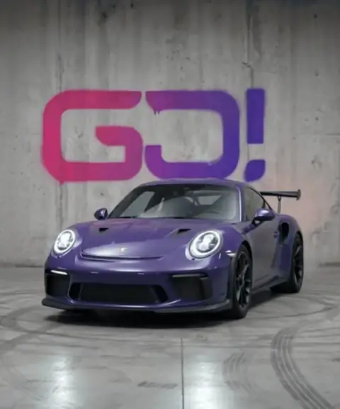 Porsche roxo com grafite GO! ao fundo, farol acendendo